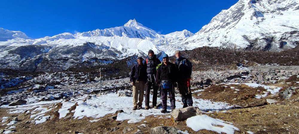 Manaslu circuit trek view with trekkers and Himalayan mountains in the background